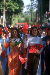VIETNAM, Ho Chi Minh City, Young women holding flags and fans on the 25th Anniversary Parade for