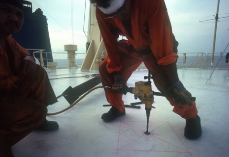 INDUSTRY, Tools, Drill, Man using a power drill on board a ship in  Indonesia.