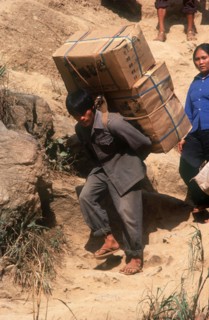 VIETNAM, Work, Smuggling on the Chinese border.  Heavily laden porter crossing to trade.