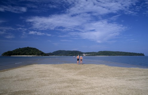 MALAYSIA, Langkawi, Kedah, Pantai Cenang beach with people walking on the sand bar at low tide to