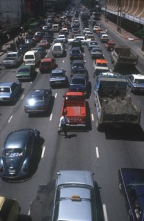 THAILAND, Bangkok, Pedestrian crossing road of six lanes of congested traffic.