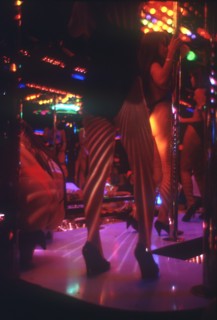 THAILAND, Bangkok, "Soi Cowboy Alley nightclub, view of stage and pole dancers, pink lighting. "