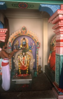 SINGAPORE, Religion, Holy man making offering at a shrine in the Sri Mariammen Temple in Chinatown.