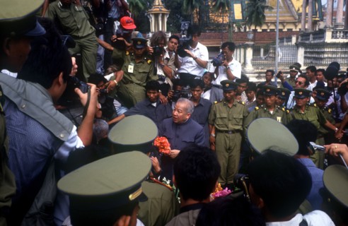 CAMBODIA, Phnom Pehn, "Sihanouk surrounded by crowds, journalists and troops at the Silver Pagoda."
