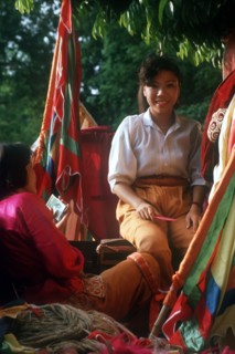 VIETNAM, Market, Woman selling brightly coloured fabrics and cloth.