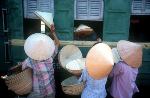 VIETNAM, Hue, "Traditional conical, straw hats being sold to train passengers at Hue station."