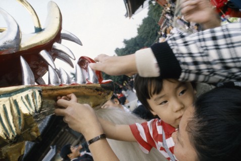 JAPAN, Festival, Young boy held up by his mother to touch the face of the dragon during a dragon