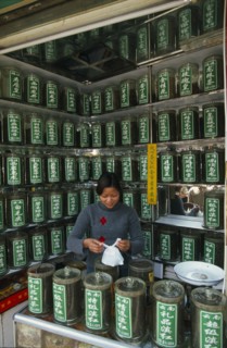 CHINA, Shaanxi Province, Xian, "Young woman serving a customer partly seen reflected in mirrored