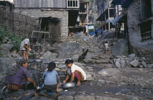 NEPAL, Annapurna Region, Dharapani, Women and children washing at piped water source in village.