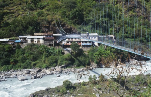 NEPAL, Annapurna Region, Transport, Suspension bridge over fast flowing river near Bhubhule with