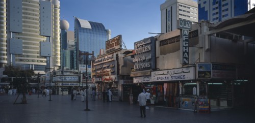 UAE, Abu Dhabi, The Old Souk. Exterior of jewellery and clothes shops with people walking through