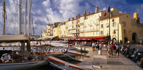 FRANCE, Provence-Cote d’Azur, St Tropez, "View along busy waterfront  with boats moored at the