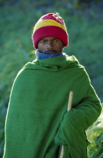 ETHIOPIA, Harerge Province, General, Portrait of young man wrapped in green woven blanket.