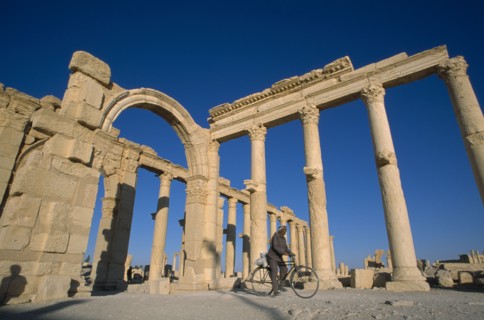SYRIA, Central, Tadmur, Colonnade and archway with man on a bicycle framed between columns.