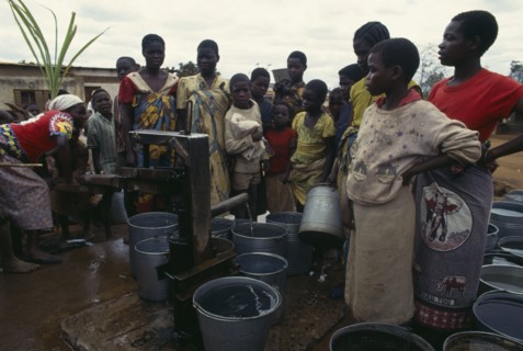 MALAWI, People, Women and children crowded around water pump with buckets.