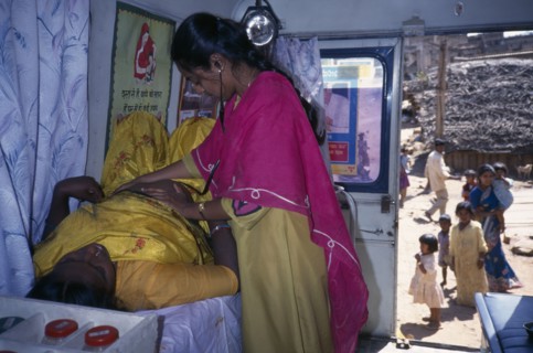 INDIA, Karnataka, Bangalore, Female health worker examining a pregnant woman in a mobile clinic.