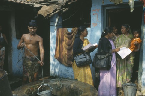 INDIA, Tamil Nadu, Madras, Women conducting a survey on reproductive health talk to a woman holding