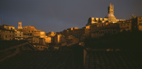 ITALY, Tuscany, Siena, View across the city rooftops towards the Duomo and Campanile in late