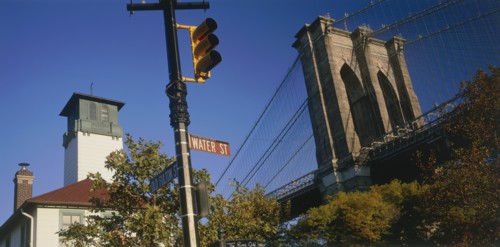 USA, New York State, New York, Part view of Brooklyn Bridge seen above trees with road sign and