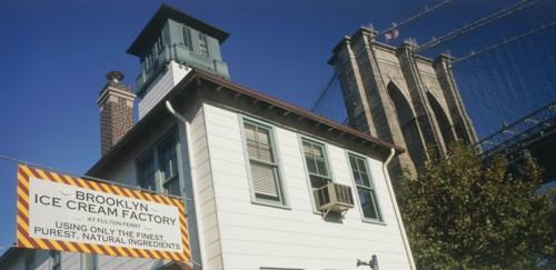 USA, New York, Manhattan, Part view of Brooklyn Bridge seen above trees with Brooklyn Ice Cream