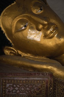 THAILAND, North, Chiang Mai, Wat Chedi Luang. Face of reclining Buddha with gold leaf on the face