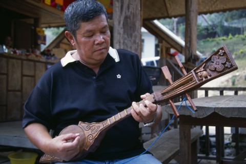 THAILAND, North, Chiang Mai, Man playing traditional stringed instrument