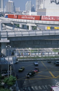 THAILAND, Bangkok, Sky Train above pedestrian walkways and road traffic at the junction of Rama 1
