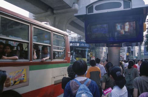 THAILAND, Bangkok, Bus and passengers at bus stop in Siam Square beside one video screen showing