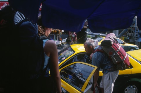 THAILAND, Bangkok, Khao San Road male backpacker talking to a taxi driver through the open