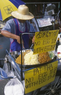 THAILAND, Bangkok, Khao San Road. Pad Thai food street stall with price signs and man preparing