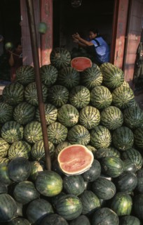 THAILAND, North, Chiang Mai, "Wholesale Food Market.  Large pile of watermelon for sale, woman with