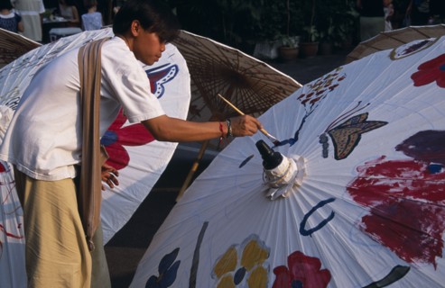 THAILAND, North, Chiang Mai, Tha Phae Road.  Young man taking part in umbrella painting competition