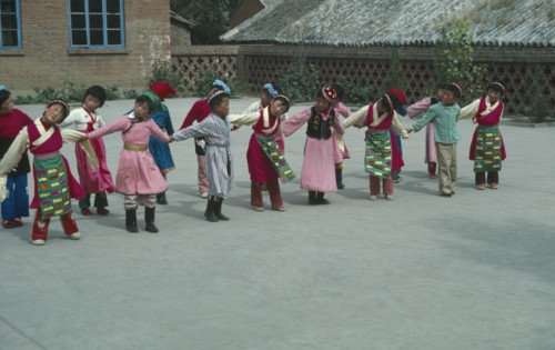 CHINA, Hebei Province, Chengde, Line of children at kindergarten with linked arms and heads