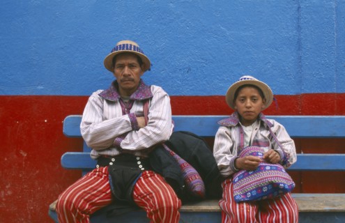 GUATEMALA, Todos Santos Cuchumatan, "Father and Son dressed identically, sitting on a blue bench
