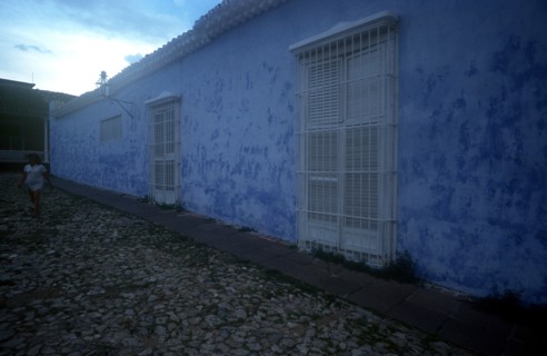CUBA, Sancti Spiritus, Trinidad, House with blue walls in cobbled street with a woman in white