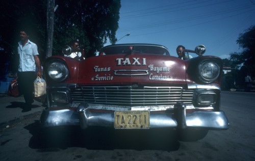 CUBA, Granma Province, Bayamo, Red 1950 s Cadillac taxi parked by the kerb