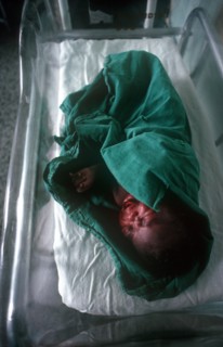 CUBA, Havana, Newborn baby wrapped in green towel in maternity hospital