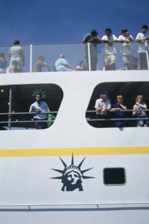 USA, New York, New York City, Circle Line ferry to Liberty Island with passengers leaning over the