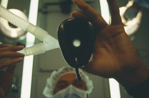 HEALTH, Operation, View looking up toward anaesthetist holding face mask from a patients