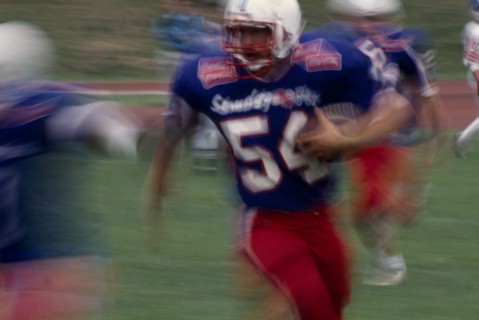 20025666 SPORT Ball Games American Football Blurred action shot of the Brighton B-52s quarter back running with the ball