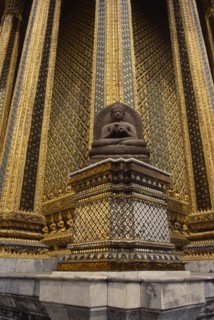 THAILAND, Bangkok, Wat Phra Kaew, Or Grand Palace. Seated buddha statue sitting against golden