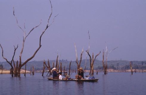 LAOS, Near Talat, Family in a canoe on a lake in a flooded valley