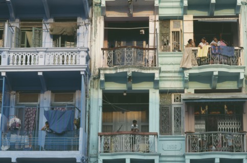 MYANMAR, Yangon, Building detail of balconies with hanging washing and people standing
