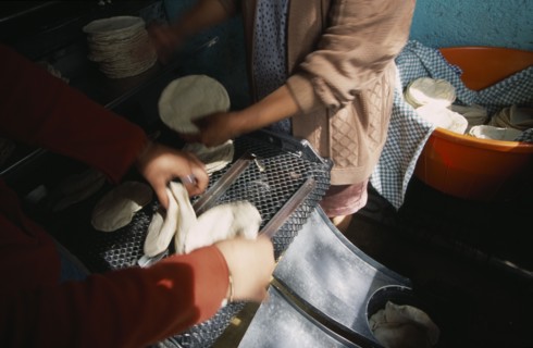 MEXICO, Mexico City, Preparation of tortillas at tortilla bakery or Tortilleria.  Cropped view of