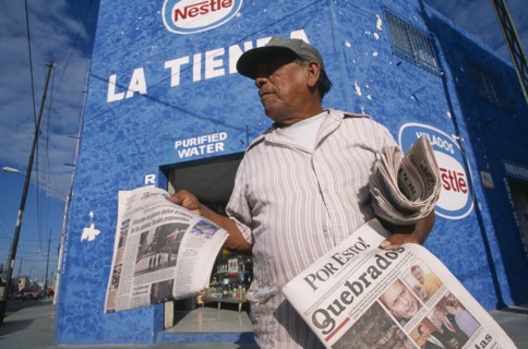 MEXICO, Yucatan, Merida, "Male newspaper vendor, threequarter view seen from below looking up.