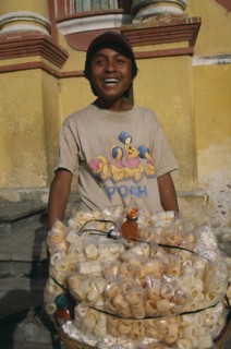 MEXICO, Chiapas, San Cristobal de Las Casas, Street food vendor with basket piled with bags of