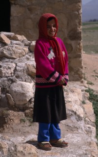 IRAN, Zagros Mountains, Qashqai nomad young girl in red and white spotted headscarf.  Standing with