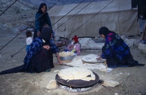 IRAN, Zagros Mountains, Qashqai nomad family making bread at a camp in the Zagros Mountains.