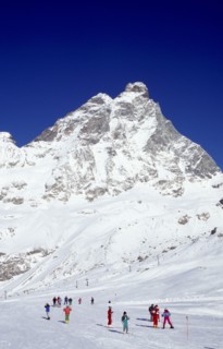 ITALY, Valle d’Aosta, Breuil Cervina, Skiers on slopes at the foot of the Matterhorn.