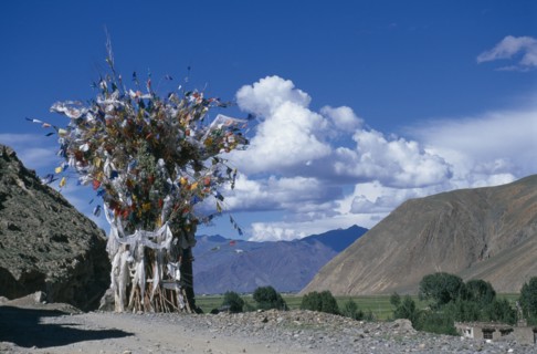CHINA, Tibet, Shigatse, Prayer flags above a chorten on the roadside.